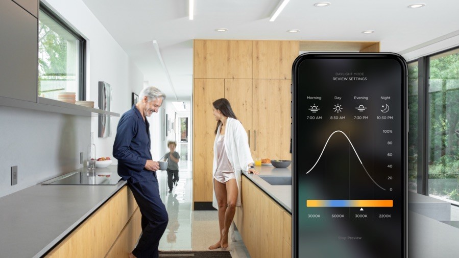 a family stand by kitchen counter. A Savant Power app is highlighted in the foreground.