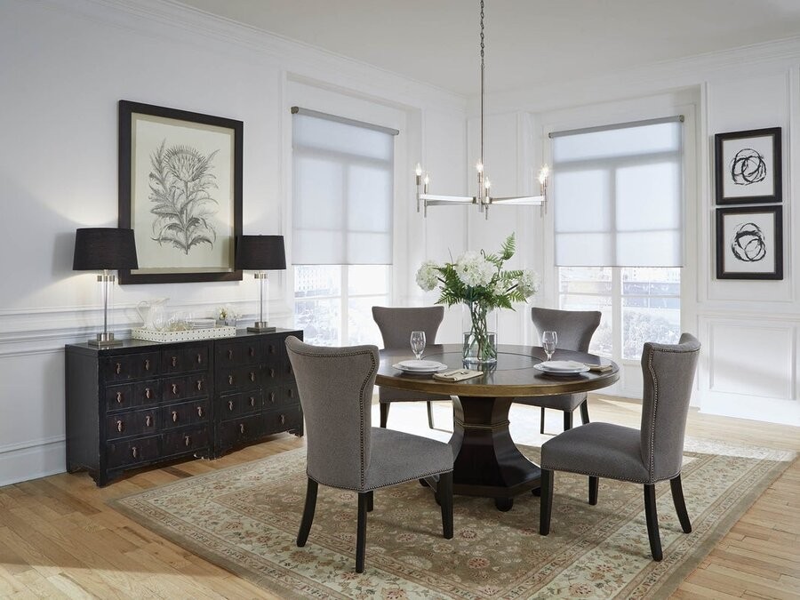 A dining space illuminated by Lutron lighting control fixtures and integrated motorized shades.